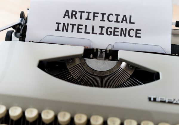 Typewriter with a paper saying "Artificial Intelligence"